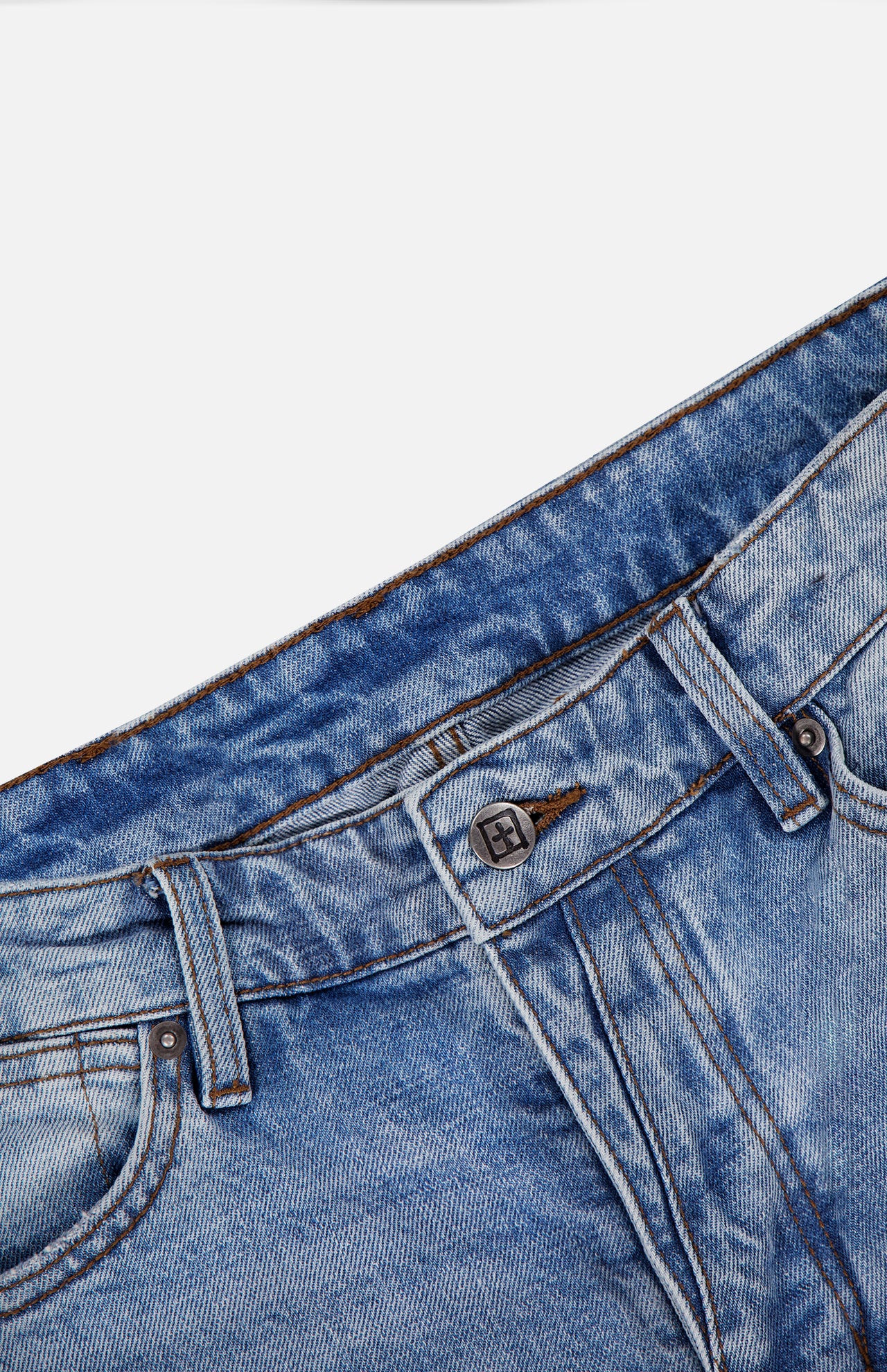 Close-up of the waist area of KSUBI’s Van Winkle Duke 4Eva Jeans in blue, highlighting the button, belt loops, and front pocket details, expertly crafted from comfort stretch denim against a white background.