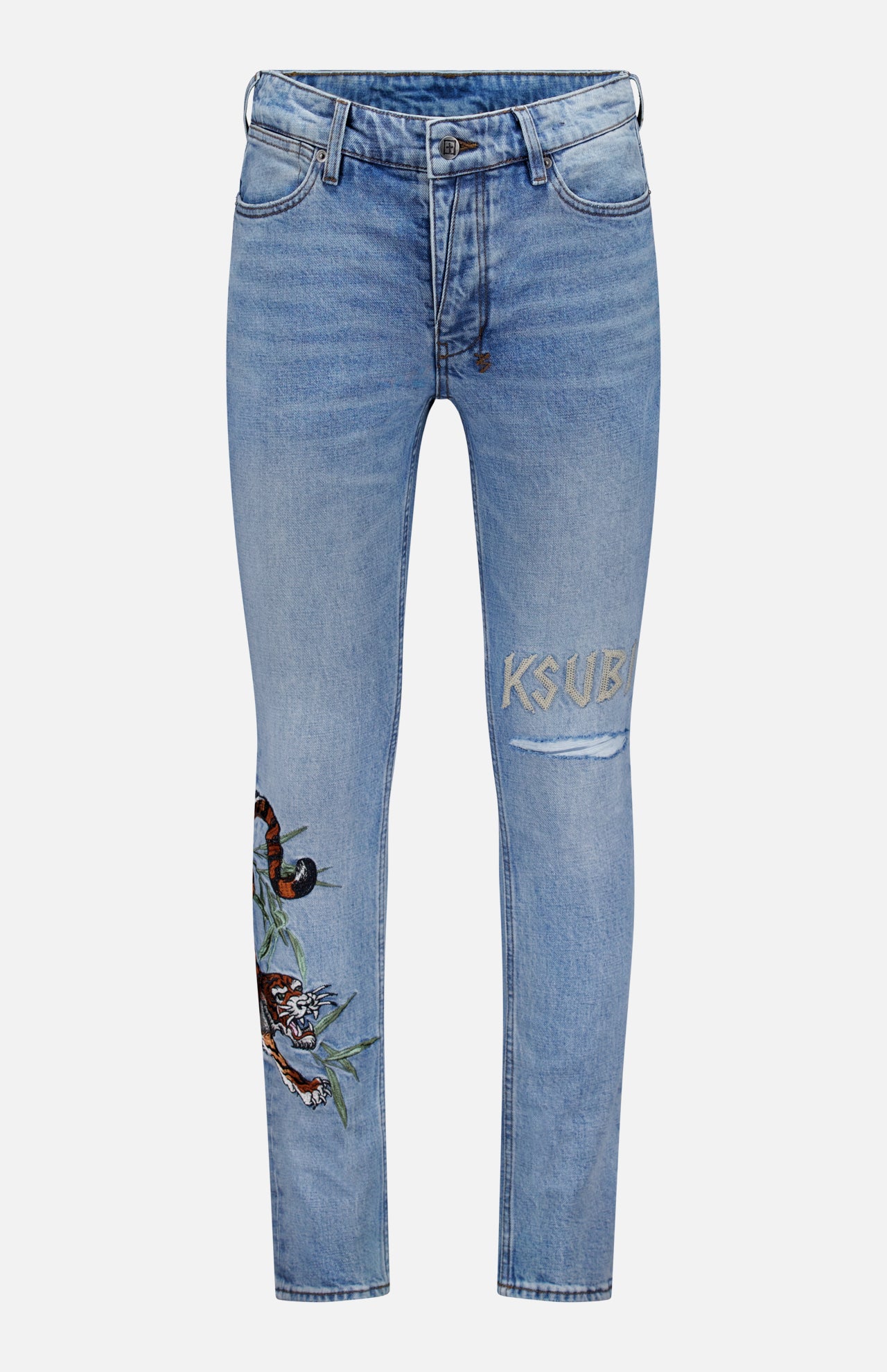 The Van Winkle Duke 4Eva Jeans by KSUBI are light blue skinny jeans made from comfort stretch denim, adorned with bold tiger embroidery and a leaf detail on one thigh, and feature the brand’s signature “KSUBI” embroidered above a rip on the other thigh.