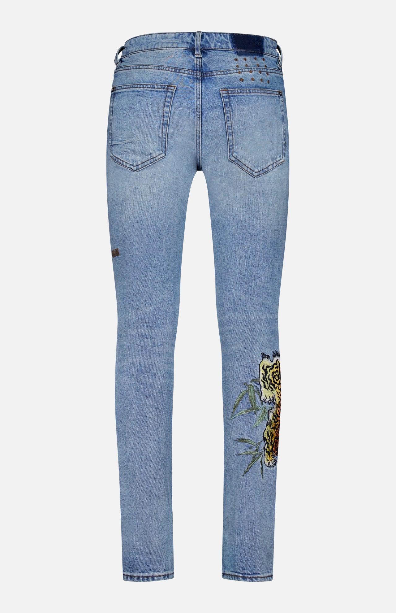 KSUBI Van Winkle Duke 4Eva Jeans in light blue comfort stretch denim, shown from the back, featuring two back pockets, a small brown patch, distressed detailing near the waistband, and a bold yellow rose with green leaves embroidered on one leg.