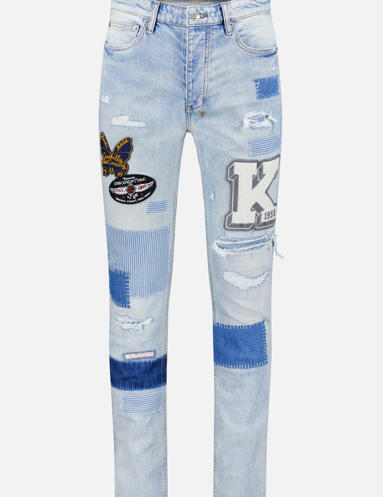 The KSUBI Repair Chitch Manhattan Jean features a slim tapered fit in light blue denim with blue and white patches, embroidered details, letter accents, rips, distressing, and a classic five-pocket design with button fly.
