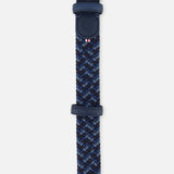 The LA BOUCLE Manhattan Belt is a one-size woven stretch belt in blue shades with leather accents near its silver buckle, a small logo, and a red, white, and blue striped detail—offering comfort and versatile style.