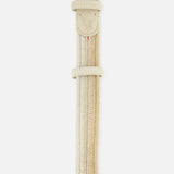 The Nice Chevron Sunset Belt by LA BOUCLE features a beige woven stretch design with leather-trimmed ends and a silver buckle, shown vertically against a white background.