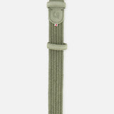 The Veneto Suede Waxed Cotton Belt by LA BOUCLE is sage green with a silver buckle, suede leather tip, embossed logo, and a stitched tricolor tag.