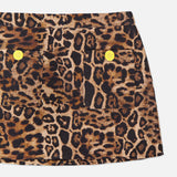 A close-up of the Cyra Low Rise Mini Skirt by L'AGENCE, showcasing a leopard print pattern with two front pockets, each adorned with a round yellow button, set against a white background.