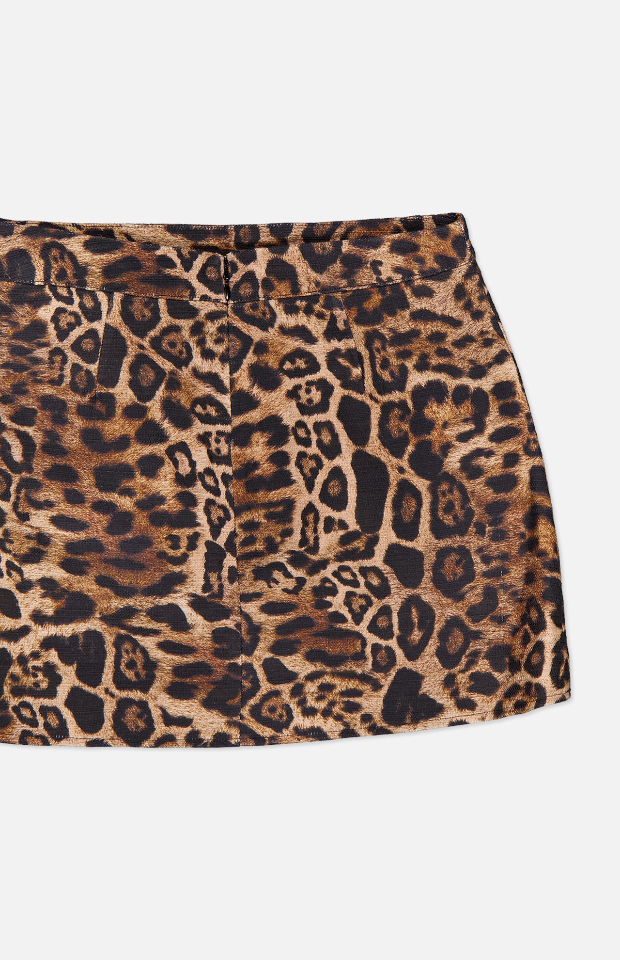 A close-up of the Cyra Low Rise Mini Skirt by L’AGENCE, featuring a brown and black leopard print, displayed on a white background.