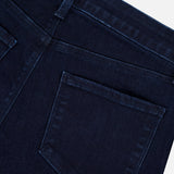 Close-up of the back of L’Agence Marguerite High Rise Skinny Jean in dark blue stretch denim, highlighting waistband, belt loop, two seams, and a single back pocket against a light background.