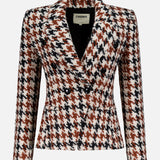 The Marie Double Breasted Houndstooth Blazer by L'AGENCE features a notched lapel, cinched waist, and brown, black, and white houndstooth pattern. Shown against a plain light gray background.
