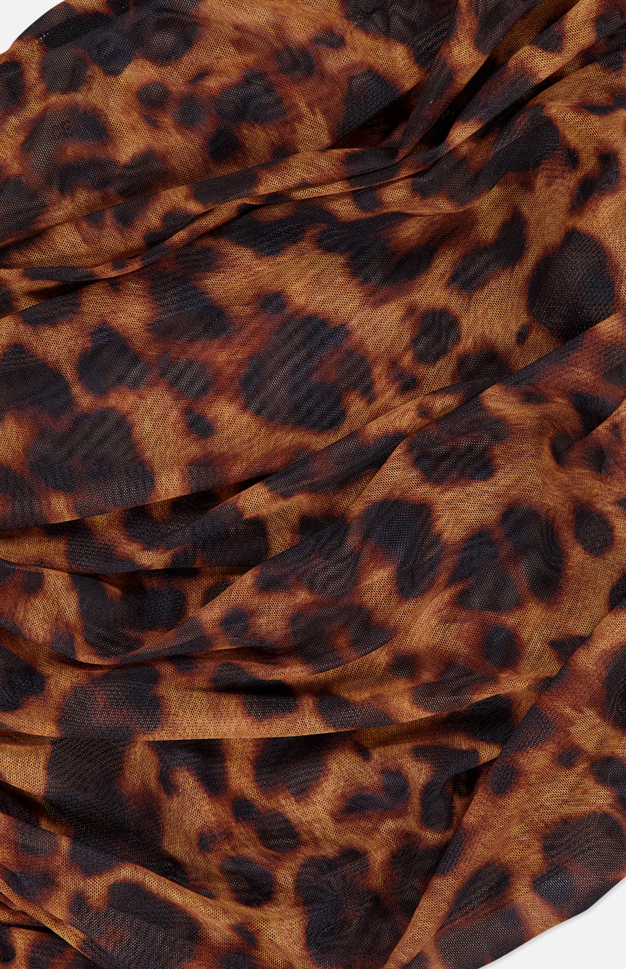 A close-up of L'AGENCE's Rasha Shirred Tank Top shows stretch mesh fabric with a leopard print—dark brown and black spots on light brown—gathered to suggest a shirred waist and a semi-sheer, stylish look.