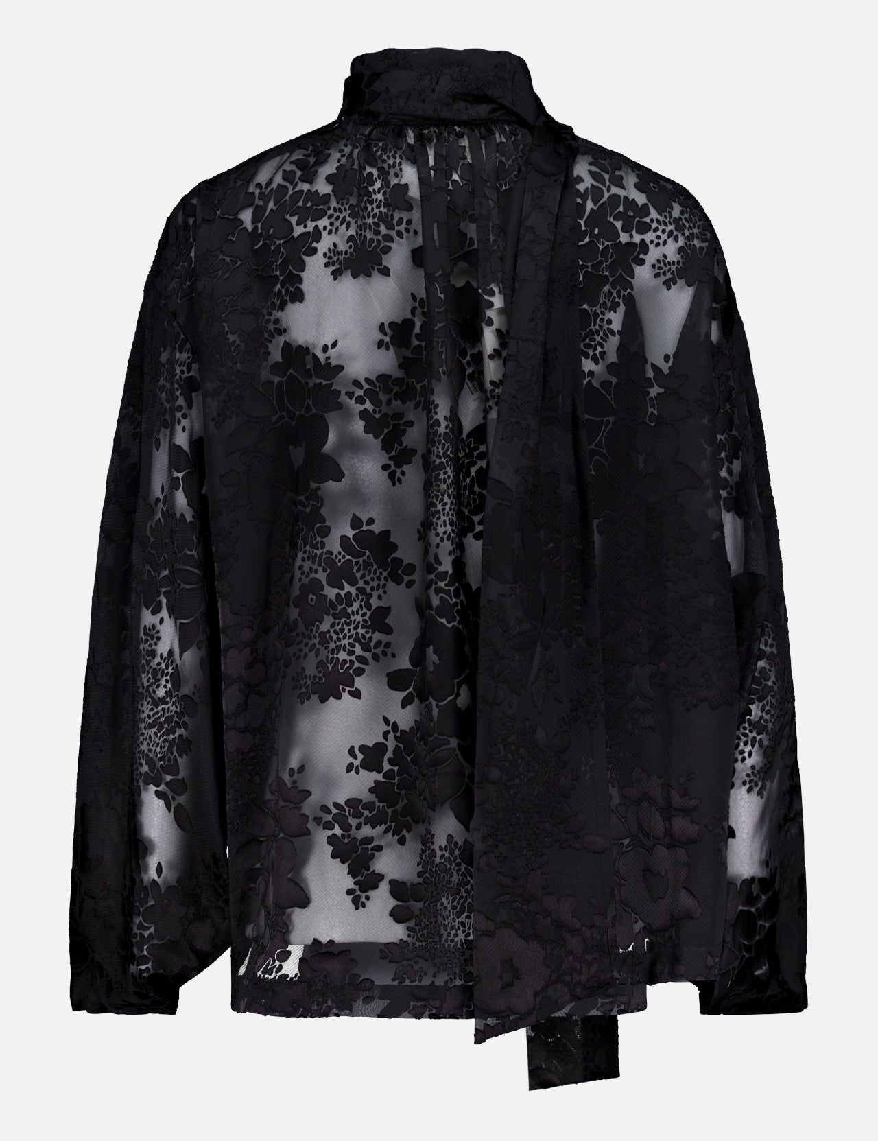 The Rhett Oversized Burnout Blouse by L'AGENCE features sheer black satin with a floral pattern, long sleeves, and an attached neck tie, adding bohemian romance to your look.
