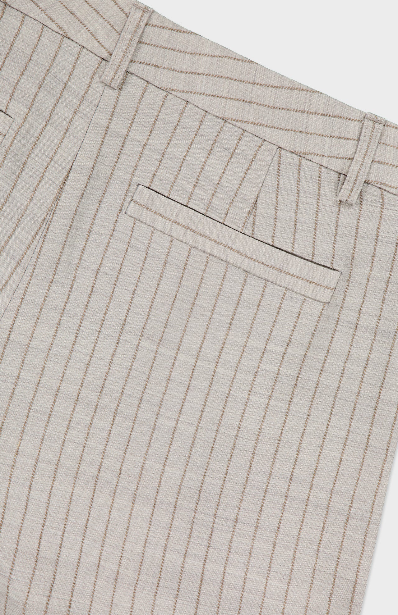 Close-up of L'AGENCE Allanah Mid Rise Trouser Pant in tan with thin brown pinstripes, showcasing the back pocket, belt loops, and waistband—a timeless tailored style.