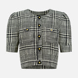 The Allegra Short Sleeve Cropped Jacket by L’AGENCE is a chic option for petite women, featuring a classic black and white plaid tweed, short sleeves, gold buttons, and two front chest pockets—beautifully presented against a plain white background.