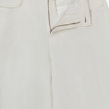 A close-up of the L'Agence Amara High Rise Wide Leg Pant in white linen shows a partially open zipper and button, revealing the waistband and inner tag. The lightweight, textured fabric is tailored for a flattering wide-leg silhouette.