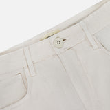 Close-up of the waistband and front pocket on the L'Agence Amara High Rise Wide Leg Pant in light beige linen, featuring a button closure, belt loops, and visible stitching.