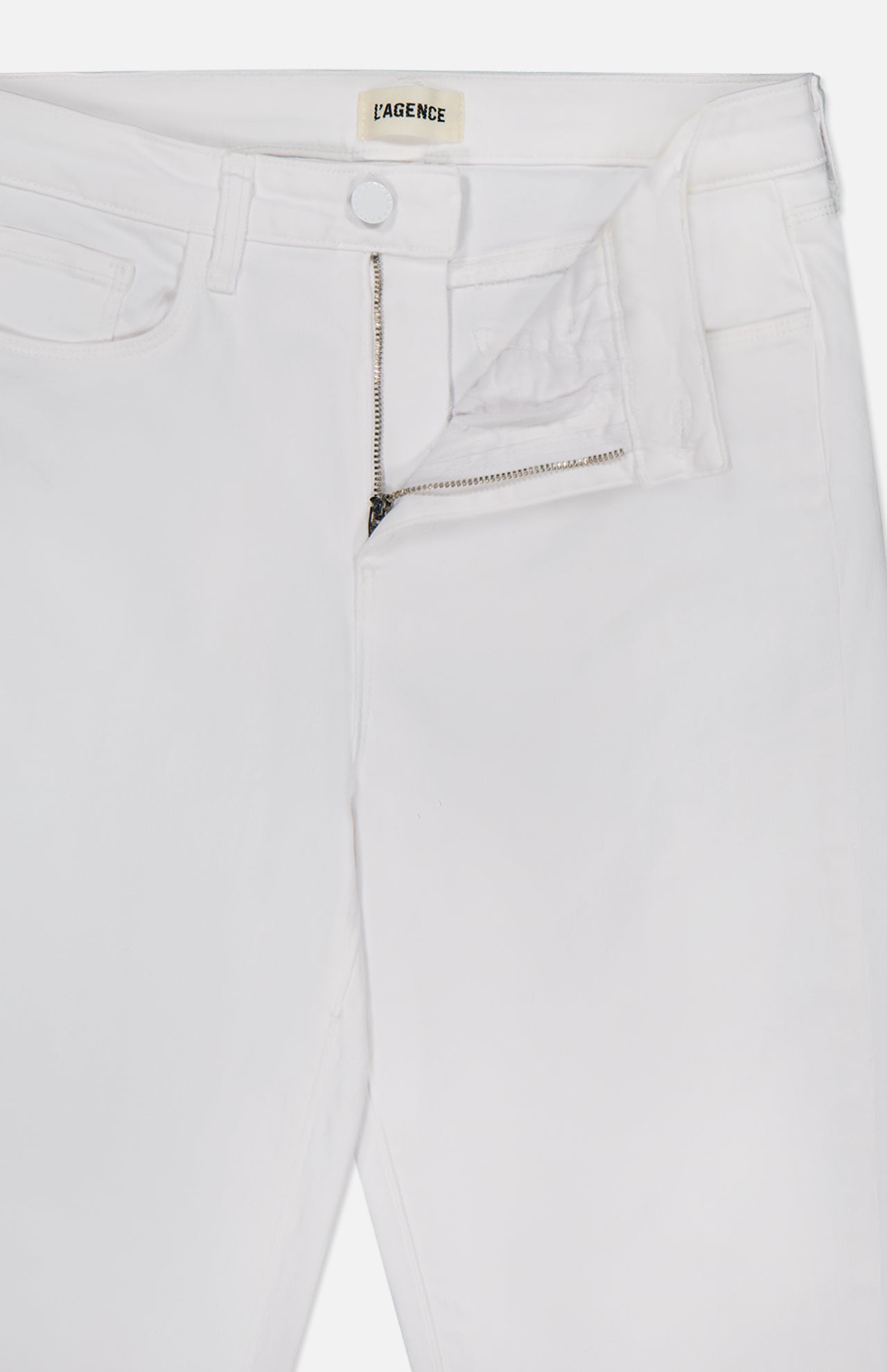 The Amaris High Rise Skinny Pedal Pusher Pants from L’AGENCE are shown in white with a partially open waistband, revealing the silver zipper, button closure, and the L’AGENCE label inside.