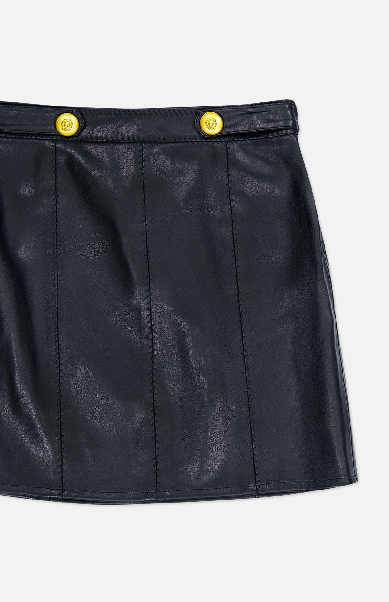 The “Arlena Whipstitch Mini Skirt” by L’AGENCE is a black vegan leather mini skirt featuring two bright yellow-gold buttons at the waistband, shown against a white background.
