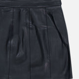 The Arlena Whipstitch Mini Skirt by L’AGENCE is a black vegan leather mini skirt featuring stitched vertical seams, a defined waistband, and a subtle sheen, showcased against a plain white background.