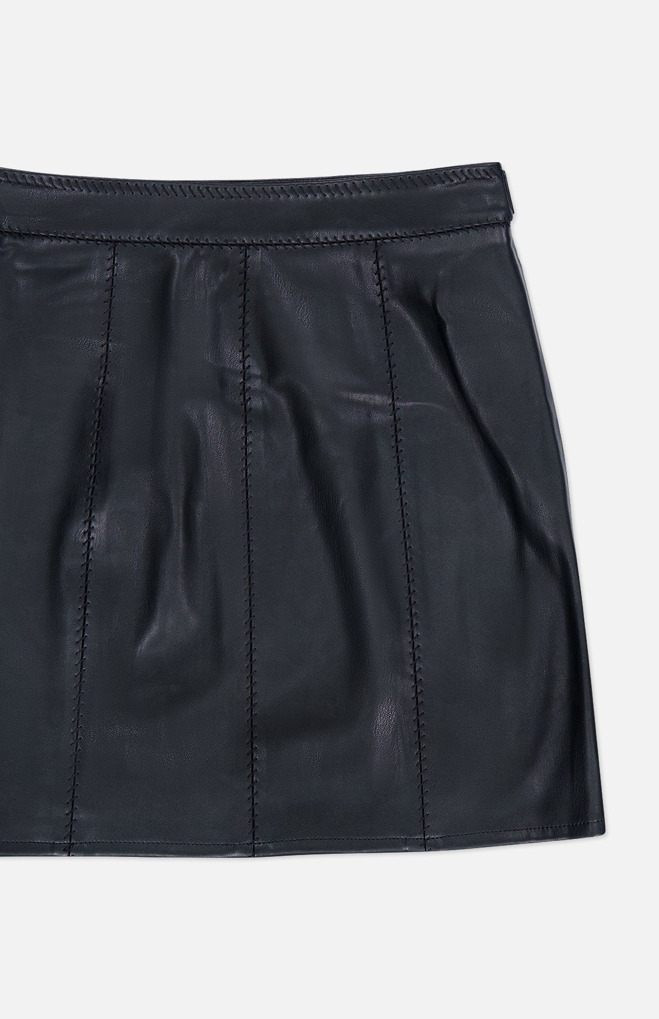 The Arlena Whipstitch Mini Skirt by L’AGENCE is a black vegan leather mini skirt featuring stitched vertical seams, a defined waistband, and a subtle sheen, showcased against a plain white background.