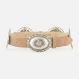 The L'AGENCE Austin Concho Medlin Belt is a tan suede belt adorned with large, oval silver conchos engraved with floral patterns, shown on a white background.