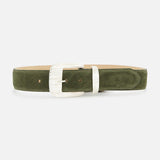 The Aya Western Engraved Belt by L'AGENCE, featuring olive green suede with a silver textured rectangular buckle and matching belt loop, is displayed flat against a white background—its Western-inspired design brings rugged elegance to any outfit.