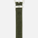 The Aya Western Engraved Belt by L'AGENCE features an olive green suede design with a silver, textured rectangular buckle and matching belt loop, photographed against a white background. This Western-inspired accessory adds a stylish touch to any outfit.