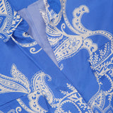 Close-up of the Cameron Long Silk Shirt Dress by L’AGENCE, featuring a blue and white paisley pattern, visible collar, buttons, pocket, and a partially visible brand label in the top left corner.