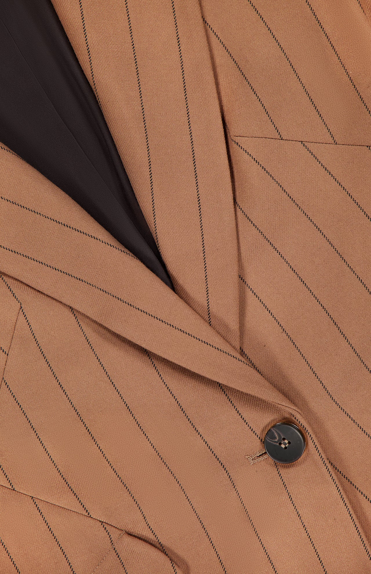 Close-up of the Chamberlain Pinstripe Blazer by L'AGENCE, showcasing its brown pinstripe fabric, black button closure, tailored lapel, chest pocket, and a glimpse of the dark inner lining—an elegant women’s office blazer.