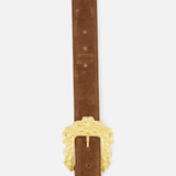 The Chayenne Ornate Double Belt by L’AGENCE is crafted from brown suede and features a large, gold-plated buckle with decorative scrollwork, showcased against a plain white background.