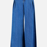 The Chayse High Rise Super Wide Leg Jean in Towson by L’AGENCE features blue denim with front pleats, side pockets, and a button closure at the waist, shown against a white background.