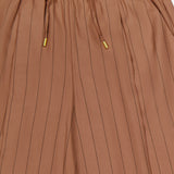 The Connie Drawstring Pinstripe Trouser by L'AGENCE showcases a light brown wide-leg silhouette with thin vertical black pinstripes, an elasticated waistband, drawstring finished with gold-colored tips, and convenient side pockets. Style it with the matching blazer for a sleek, coordinated ensemble.