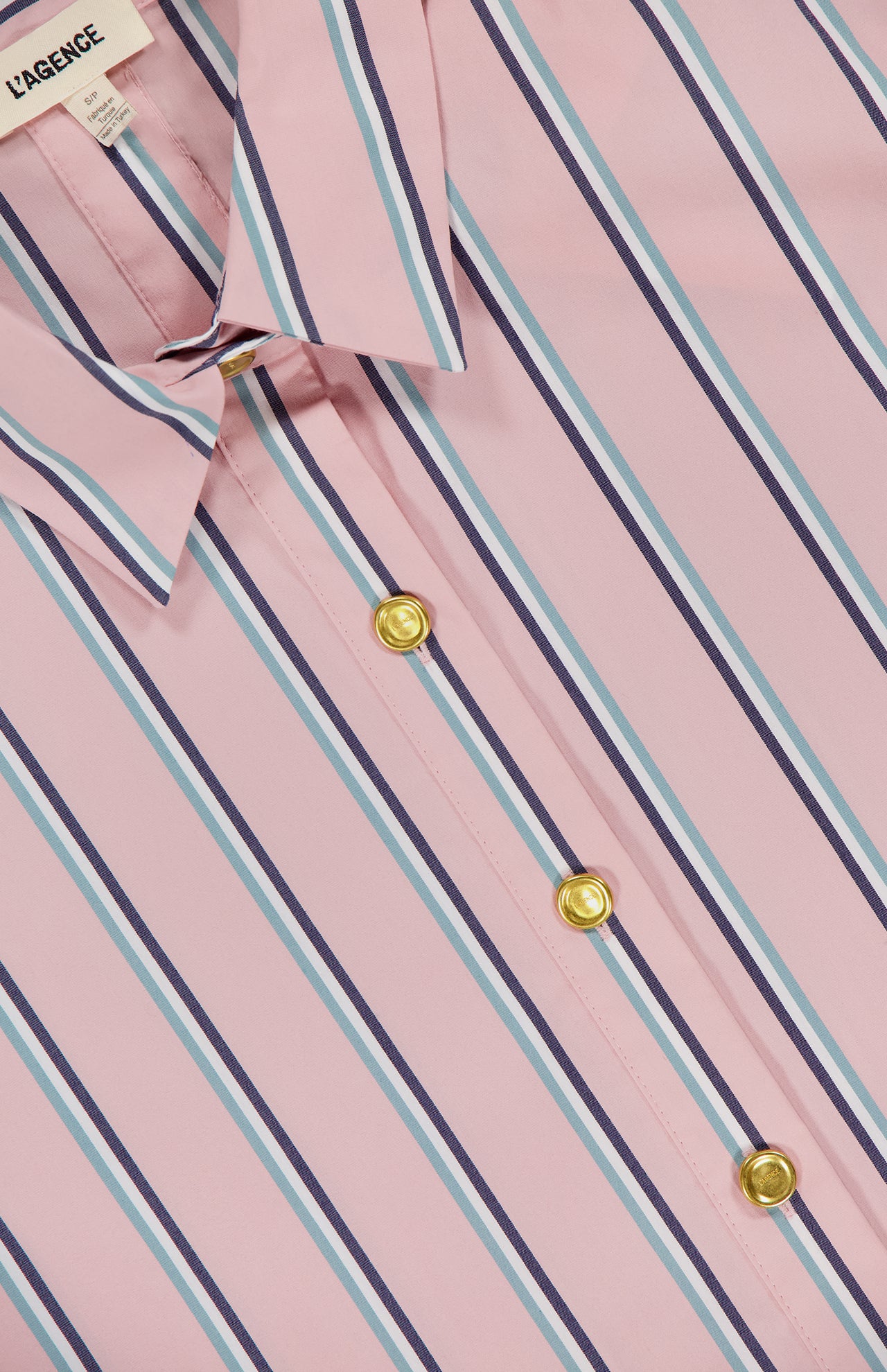 Close-up of the L'AGENCE Cosette Crop Hi Low Shirt in pink with blue and white vertical stripes, gold buttons, and a cropped high-low hem.