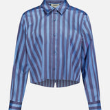 The Cosette Cropped Hi Low Shirt by L'AGENCE features long sleeves, a pointed collar, a slightly cropped hem, and vertical and diagonal blue and purple stripes.
