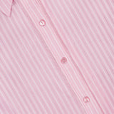 Close-up of the L'AGENCE Cosette Cropped Back Slit Shirt, featuring soft cotton in light pink with subtle vertical stripes, white buttons, and the collar visible at the top left.