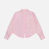 The L'AGENCE Cosette Cropped Back Slit Shirt is a light pink, long-sleeve cotton shirt with subtle white stripes. Shown from the back against a white background, it features a straight collar, buttoned cuffs, and a refined finish.