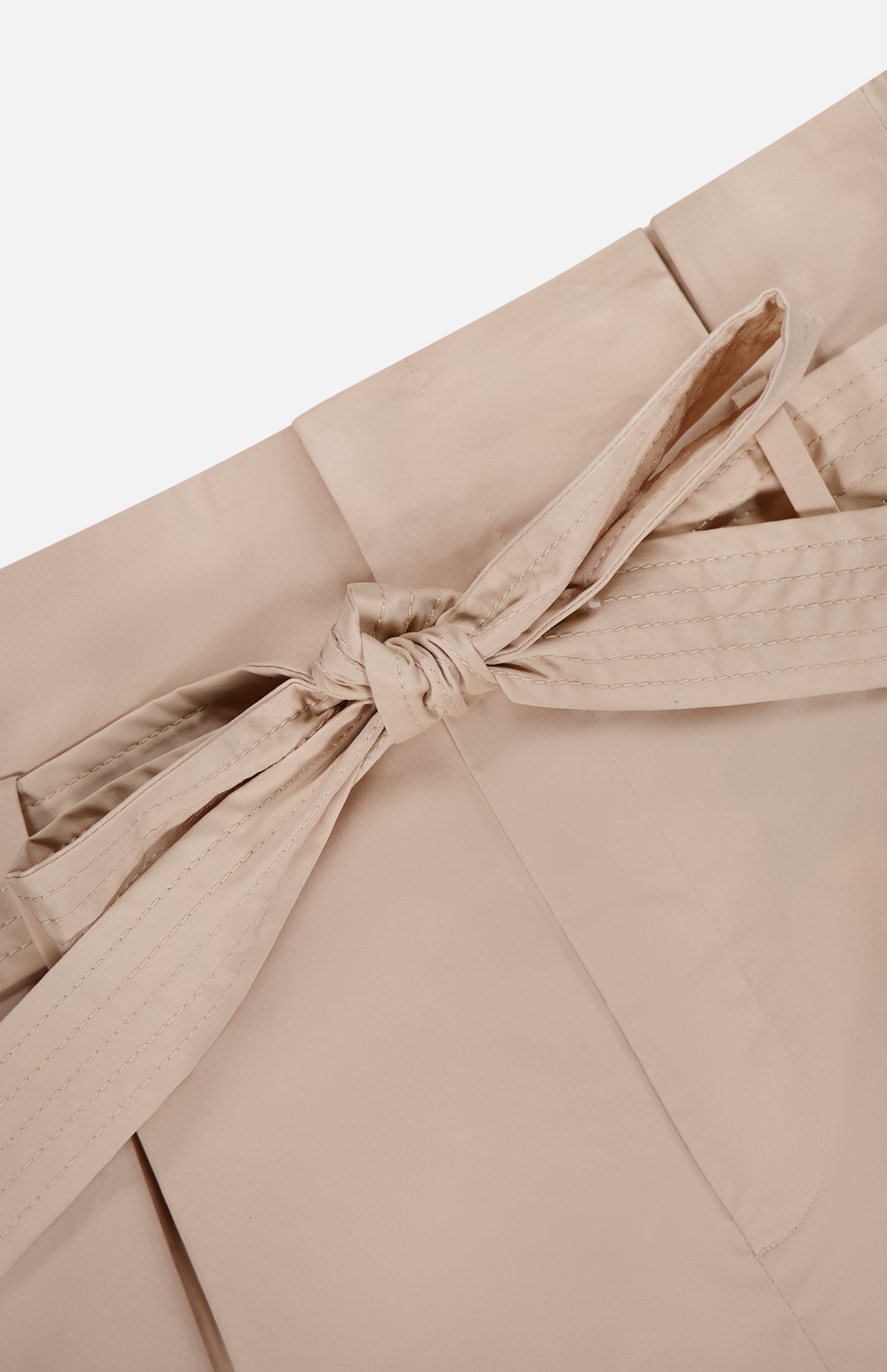 Close-up of the beige self-tie belt in a bow at the waist of L'AGENCE’s Damira Paperbag Short, showcasing the stitching and smooth material.