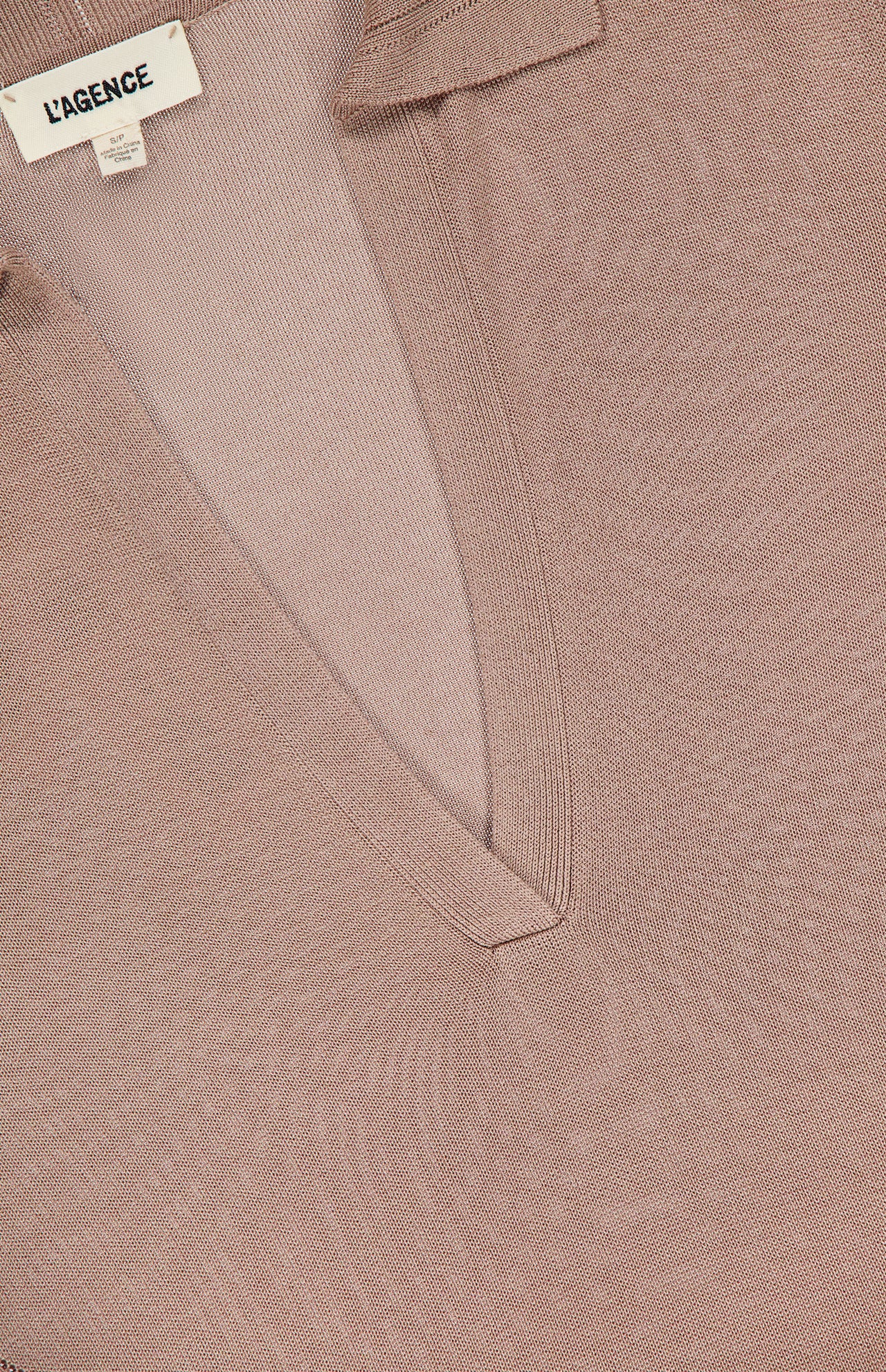 Close-up of the Delma Collared Knit Maxi Dress by L’AGENCE in taupe, featuring a V-neckline, small collar, and soft silk-like knit fabric. A white "L'AGENCE" label is sewn inside the neckline.