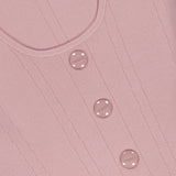 Close-up of the Dove Scoop Neck Knit Corset Top by L'AGENCE, a sleeveless pale pink power knit with vertical stitching and four round pink buttons embossed with “MUSIER” down the front.