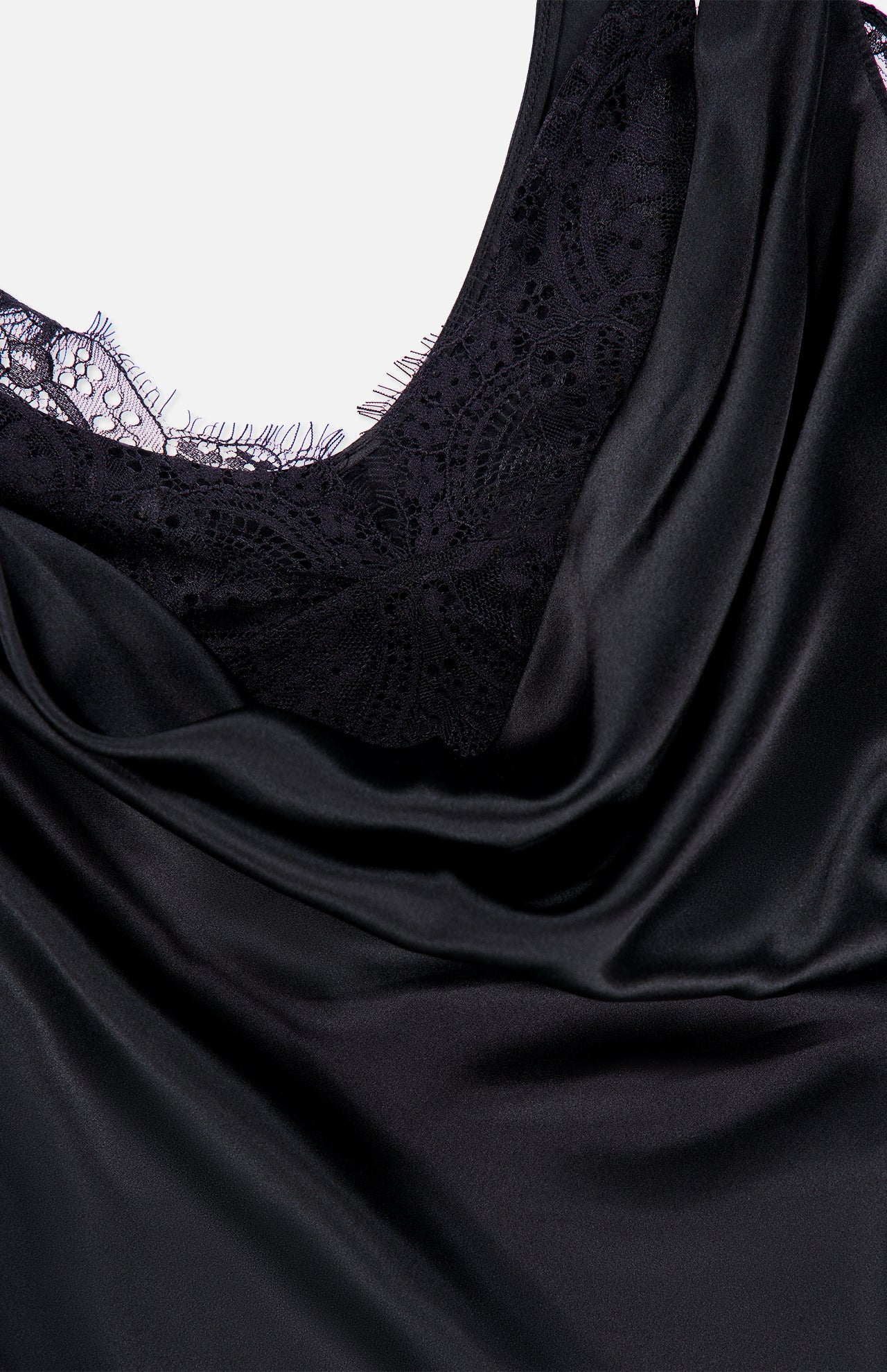 Close-up of the L’AGENCE Evadne Cowl Neck Tank Top, featuring black satin fabric draped over intricate lace detailing and showcasing the top’s shiny, smooth satin texture.