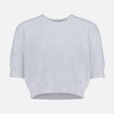 The L'AGENCE Guinevere Short Sleeve Cropped Crewneck Shirt features a pale blue hue, short sleeves, a crew neck, and a relaxed fit, shown against a white background.