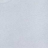 Close-up of a pale blue Guinevere Short Sleeve Cropped Crewneck Shirt by L'AGENCE, featuring textured knit and ribbed neckline. A small tag inside the collar reads L'AGENCE.