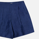 The Hadleigh Long Linen Short by L'AGENCE features a dark blue linen blend, high rise, shiny finish, front pleats, and a side zipper closure, shown against a plain white background.