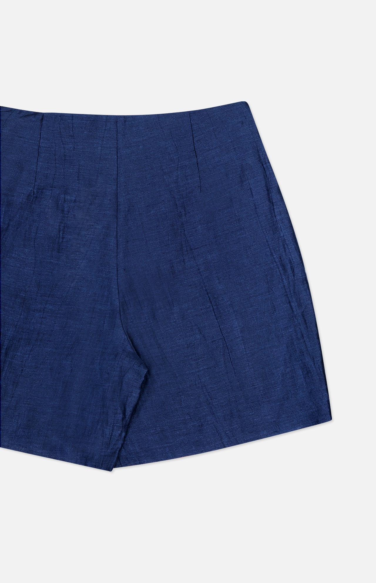 A close-up of the Hadleigh Long Linen Short by L'AGENCE—high rise blue linen dress shorts with a smooth texture and flat front, photographed against a white background.