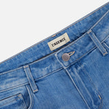 Close-up of the waistband and upper portion of L’AGENCE Joanne Low Rise Wide Leg Jean in Pacific, featuring light blue vintage denim, a metal button, and an interior L’AGENCE brand label.