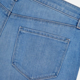 Close-up of the back pocket and waistband of the L'AGENCE Joanne Low Rise Wide Leg Jean in Pacific, highlighting the stitching and textured light blue denim against a white background.