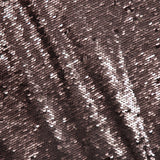 Close-up of the L’AGENCE Karma Sequin Maxi Dress, featuring fabric densely covered in small, shiny rose gold sequins reflecting light and forming a shimmering, textured surface with diagonal patterns—an elegant choice for special occasions.