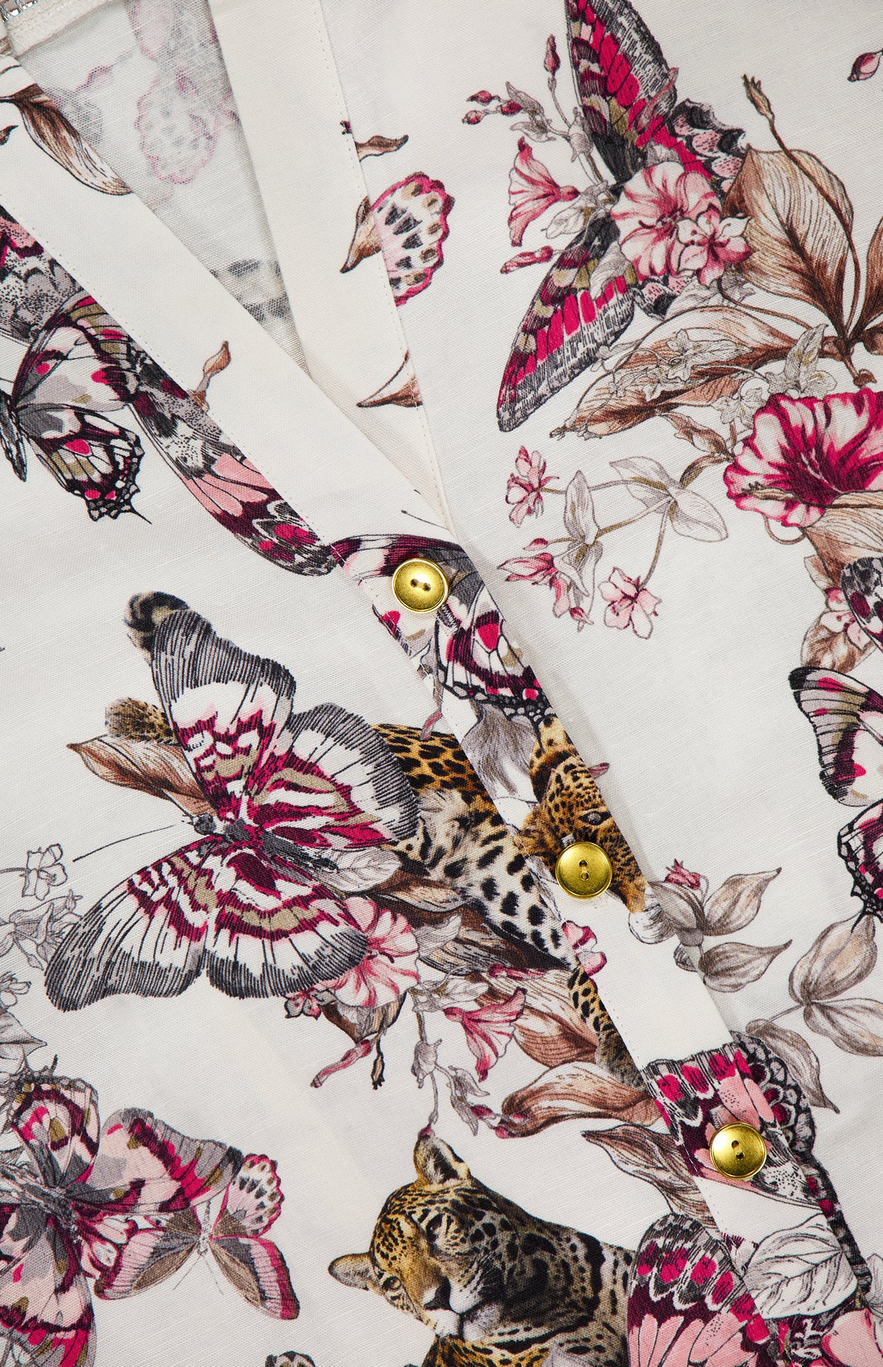 Close-up of the Kiersten Long Puff Sleeve Dress by L'AGENCE in white, featuring a butterfly, flower, and leopard print with gold buttons on the placket for an elegant touch.