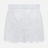 The L'AGENCE Laina Pull On Eyelet Short features a floral eyelet design, elastic waistband, scalloped hem, and cotton lining with a semi-sheer overlay for a delicate look.