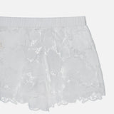 The L'AGENCE Laina Pull On Eyelet Short showcases a floral lace pattern, cotton lining for comfort, a scalloped hem, and an elastic waistband. Shown against a plain white background.