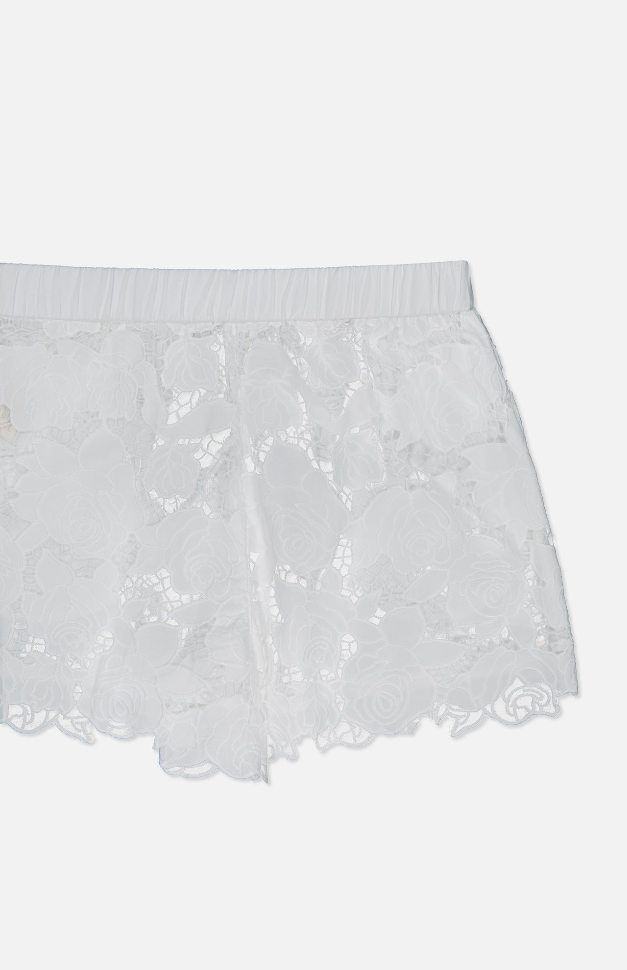 The L'AGENCE Laina Pull On Eyelet Short showcases a floral lace pattern, cotton lining for comfort, a scalloped hem, and an elastic waistband. Shown against a plain white background.