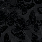 Close-up of the Laurent Button Up Butterfly Blouse by L’AGENCE, featuring sheer black fabric with a velvet butterfly pattern and visible buttons. The top left corner partially reveals the L’AGENCE clothing label, showcasing the exquisite details of this burnout velvet statement blouse.