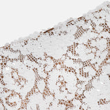 Close-up of the Makena Sequin Pencil Skirt by L'AGENCE, featuring white sequins in a lace-inspired pattern on sheer nude fabric. Its elegant, textured shine is ideal for chic bridal parties or sophisticated events.